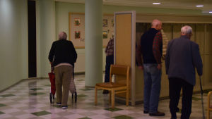 Efter lunchen är det dags att ge sig av till nästa aktivitet. Äldre personer går i en korridor på dagverksamheten i Ekenäs.