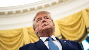 USA:s president Donald Trump fotad underifrån med ett gult draperi i bakgrunden. 