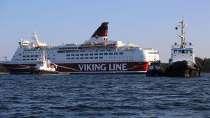 Bogserbåtar förbereder flytten av M/S Amorella som sitter fast i lerbottnen. Tre bogserbåtar syns nära M/S Amorella vid Julgrund nära Järsö på Åland.