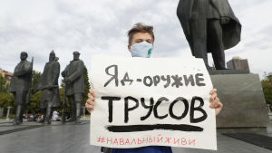 Ryska lagstiftare vill sätta stopp för enmannaprotester såsom denna i Novosibirsk den 20 augusti. På skylten står det "Gift är ett vapen för fegingar. Håll dig vid liv Navalnyj." En man i munskydd står bredvid en staty och håller upp en skylt där det på ryska står gift är ett vapen för ynkryggar. Hål dig vid liv Navalnyj.