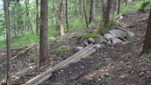 Här har använts endast några smala trädstammar och stenar för att att förbättra den branta lutningen. En bit av rutten längs terrängscyklingsbanan som byggs i Fiskars.