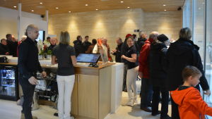 Receptionen med café var fylld med folk genast efter öppningen. Receptionen i ett spa. Många gäster. Invigning.