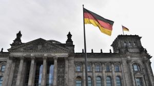 Riksdagshuset i Berlin. I förgrunden ser man den tyska flaggan vaja i vinden.