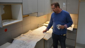Rummen börjar ta form och köken är uppskruvade men nu är det mest problem med ventilationen och de justeringar som krävs, berättar vd Patrik Fellman. Medelålders man tittar på ritningar i Tavasthem i Kåren i Åbo.