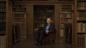 Dan Brown sitter och väntar på att få komma till Helsingfors författaren dan brown sitter i ett bibliotek