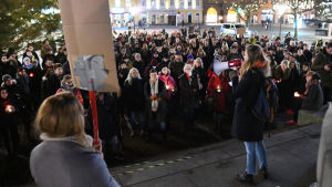 Sverige har nuförtiden samtyckeslag. Några hundra personer demonstrerar på ett torg. I förgrunden kvinna med plakat och kvinna med megafon.