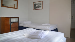 Det finns en, två och tre personers rum. Ett hotell rum med två vita sängar i Johannisberg.