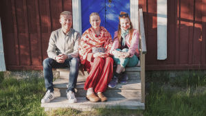 Ulrika Vestergård-Denward tillsammans med Egenlands programledare Nicke Aldén och Hannamari Hoikkala på trappan till Svennas stuga vid Granösunds fiskeläge. Egenlandin juontajat Nicke Aldén ja Hannamari Hoikkala istuvat rappusilla yhdessä Ulrika Vestergård-Denwardin kanssa.