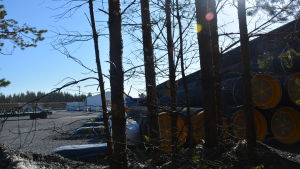 Rör i Koverhar hamn. Bild på rör inne på ett industriområde. I förgrunden syns träd