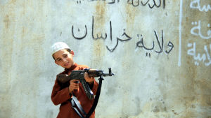 Barn som har vuxit upp under Islamiska Statens styre i krigszoner kan vara svårt traumatiserade Ett barn i IS leker med automatvapen.