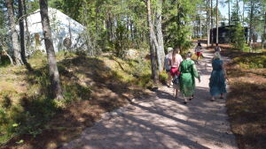 Besökare går tillsammans med Kristina Roth på ön i augusti 2018. kvinnor på promenadväg i skog