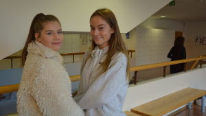 Bettina Fellman och Hilda Wärnhjelm. Två flickor i ljusa kläder poserar invid ett räcke.