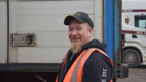 Mikael Wikstedt kör motorcykel på sin fritid. På jobbet är det fler hjul som gäller. en man med keps o orangefärgad reflexväst som har en långtradare med släp bakom sig