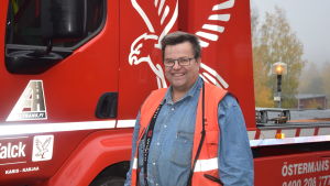 Ulf Österman har sett slitna däck och dåligt fastsatta släp, men oftast är det ett litet elektroniskt fel som stoppar långtradaren. en man med röd väst står framför en röd bärgningsbil.