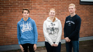 Rebecca Sandfors (i mitten) säger att projektet varit tungt men samtidigt roligt, eftersom de behandlat ämnena bland annat genom lekar. Samuel Berg (till vänster) och Robin Forsman tycker att projektet varit lärorikt. Tre studerande står framför en tegelvägg. Samuel Berg (t.v.), Rebecca Sandfors och Robin Forsman.