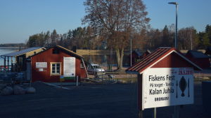 Förutom pågående byggprojekt i hamnen skapar byarådet och de andra föreningarna i Bromarv ständigt nya evenemang. Allt för att göra byn attraktiv för både bybor och sommargäster. EN skärgårdshamn med strandbodar i rött. Morgon i april. Soligt. I förgrunden en skylt som berättar om kommande evenemang. Fiskens fest i slutet av maj.