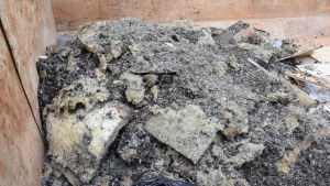 Sopcontainern utanför motellet fylls sakta, men säkert av isoleringsmaterial, sot, aska och annat skräp. Mineralull (isoleringsmaterial) och sot i en sopcontainer.