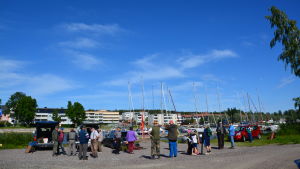 Före tävlingen samlas alla deltagare för att umgås och få ett startnummer. Grupp med människor står och väntar på att en fisketävling ska börja.
