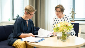 Krista Mikkonen on jo kymmenes ympäristöministeri, jonka sihteerinä Kristina Tamminen toimii. Krista Mikkonen ja sihteerin Kristina Tamminen neuvottelevat.