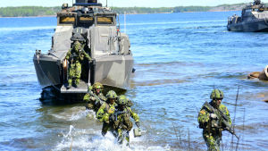 Svenska kustjägare landstiger från en finländsk JEHU-transportbåt under en gemensam övning i Hangö, juni 2019. svensk militär personal vadar i vatten från båt