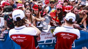 Antonio Giovinazzi och Kimi Räikkönen skriver autografer.