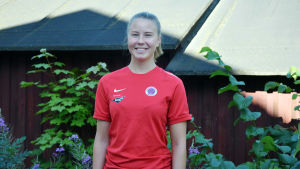 Ida Adamsson säger att det är roligt att rätt långt få koncentrera sig på fotboll. Porträttbild på Ida Adamsson i röd t-skjorta. Hon ler på bilden.