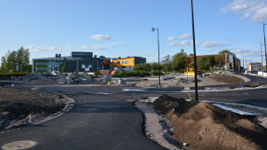 Det som ska bli anslutningsparkeringen vid Stora Byvägen. Till höger, utanför bilden, finns rondellen som man också nyss har byggt. En byggarbetsplats bestående av asfalterade vägar och en stor sandplan.