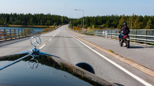 Ralf Ingmans Mercedes fick leda konvojen. Vy inifrån en Mercedes som blir omkörd av en moped.