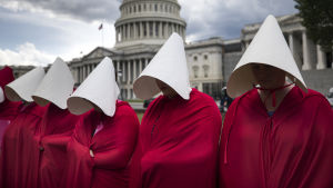 Scen ur The Handmaid's Tale. Kvinnor som protesterar i Washington D.C. iklädda den kännspaka kostymen från tv-serien The Handmaid's Tale.