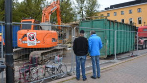 Rivningen intresserar förbipasserande Borgåbor. Två personer följer med när en byggnad rivs.