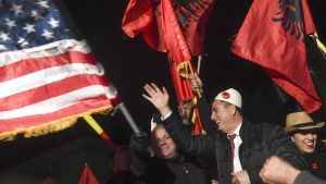 Kurtis anhängare viftade också med USA:s flagga. USA är populärt i Kosovo allt sedan mars 1999, då Nato började bomba Jugoslavien på initiativ av USA och Kosovokriget tog slut. Albin Kurti ses i mitten av bilden, omgiven av flaggor och personer som firar.