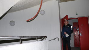 Servicechef Juha Partanen besöker stadshuset ungefär en gång i veckan. En man med lampa i pannan tittar på en röd ledning som hänger från taket.