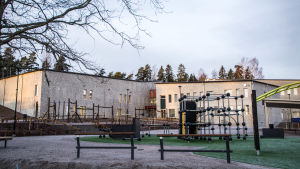 Skolan har flera olika ingångar. Den här ser man om man kommer gående från läkarcentralen. Klätterställningar, och i bakgrunden ett skolhus