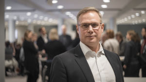 Niclas Grönholm säger att läget ser lovande ut också inför årsskiftet. En man ser in i kameran. Han har en neutral min. I bakgrunden syns folk som pratar.