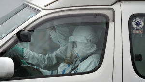 Ambulanspersonalen var klädd i full skyddsdräkt då de hämtade en smittad passagerare från Diamond Princess på söndagen. Ambulanspersonalen var klädd i full skyddsdräkt då de hämtade en smittad passagerare från Diamond Princess på söndagen.