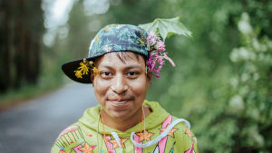 Vicotr Lehtinen gillar att åka på läger. pojke med skärmmössa på svaj och blommor i håret