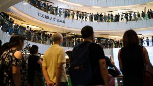 Demonstrationen inleddes som en sjungande flashmob i köpcentret. Demonstranter sjunger i ett köpcenter i Hongkong.