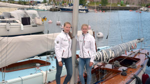 Catharina och Cecilia Sandman ombord på den gamla träbåten. Catharina Sandman och Cecilia Sandman står vid masten på deras tävlingssegelbåt.