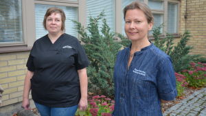 Närvårdarna Tea Laiho och Satu Elina Laamanen ser fram emot sina nya jobb. Två mörkhåriga kvinnor vid en tegelvägg.