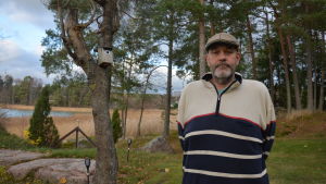 Jan Eriksson vill att kommunikationen i församlingen ska bli bättre. Man i keps står bland träden.