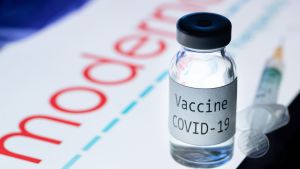 En vaccinspruta och liten flaska där det står covid-19.