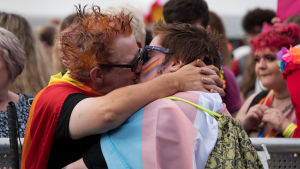 Lagen som förbjöd homosexualitet kom att lämna en lång skugga i Finlands regnbågshistoria. Två kvinnor kysser varandra i samband med en Pride-parad.