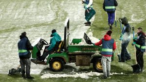 Många funktionärer fick slita för att matchen mellan Osasuna och Real Madrid skulle bli av. Planfunktionärer lastar bort snö från gräset.