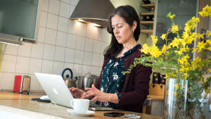 Många har jobbat på distans under pandemin och många kommer troligtvis att fortsätta med det, vilket ställer höga krav på framtida nätförbindelser. En kvinna står och jobbar vid en bärbar dator.