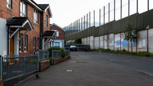 Så kallade fredsmurar som skiljer åt protestantiska och katolska områden präglar stadsbilden på många håll i Belfast och andra nordirländska städer. Bostadshus i rödtegel alldeles nära en flera meter hög mur.