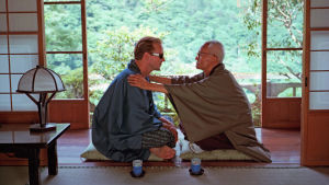 Kaksi miestä istuu lattialla vastakkain japanilaisittain. Kuva elokuvasta Maailman ääriin.