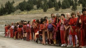 Ivriga människor väntar på Oshos ankomst till Rajneeshpuram år 1984. människor på rad