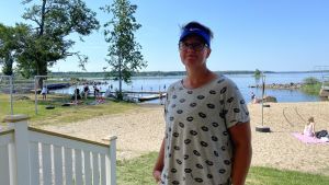 Malax Folkhälsas ordförande Maria Storfors tycker att arrangemanget har fungerat bra. Maria Storfors står brevid ett vitmålat räcke med en badstrand i bakgrunden.