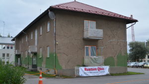Aravahuset före muralmålningen. Aravahuset före väggmålningen. Brungrått rappat hus.