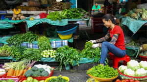 Kvinna i grönsakshandel i Ho Chi Minh i Vietnam Kvinna i grönsakshandel i Ho Chi Minh i Vietnam